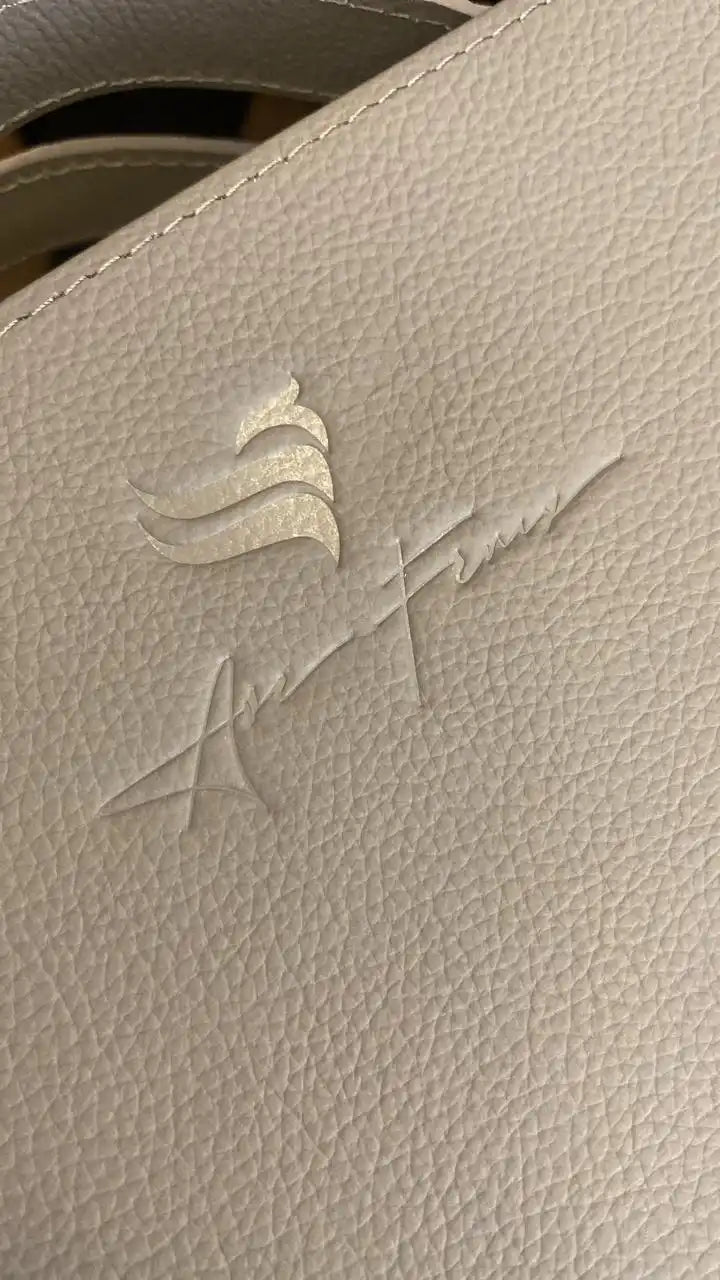 Cuero de color crema con un logotipo en relieve.