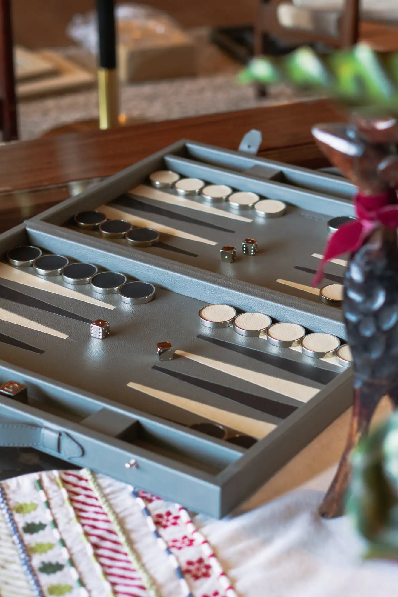 Juego de backgammon con madera oscura y piezas de metal, con un diseño de tablero en azul claro.