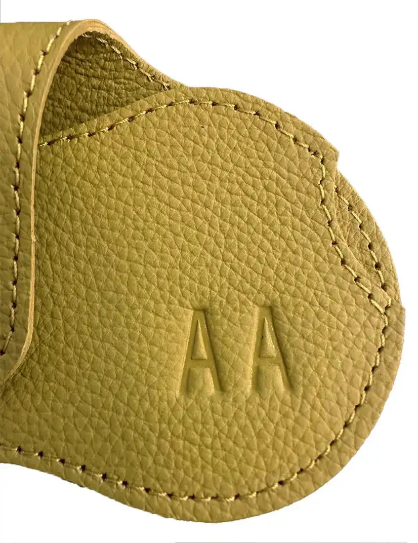 Llavero de cuero texturizado en tono canela con iniciales 'aa' en relieve.