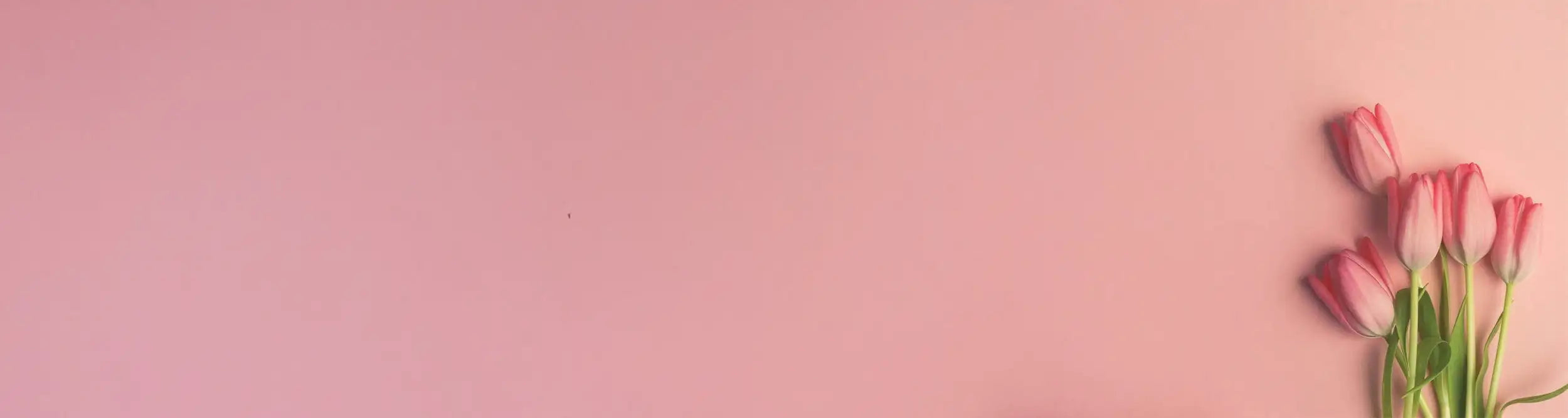 Un racimo de tulipanes rosados delicados con tallos verdes dispuestos contra un fondo suave en tonos pastel.