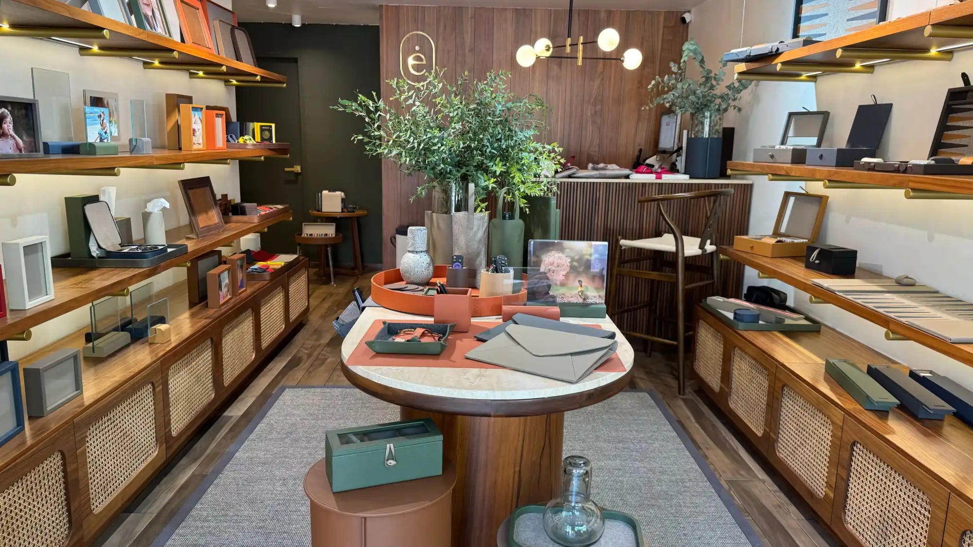 Mesa de exhibición circular de madera con mercancía minorista dispuesta encima.