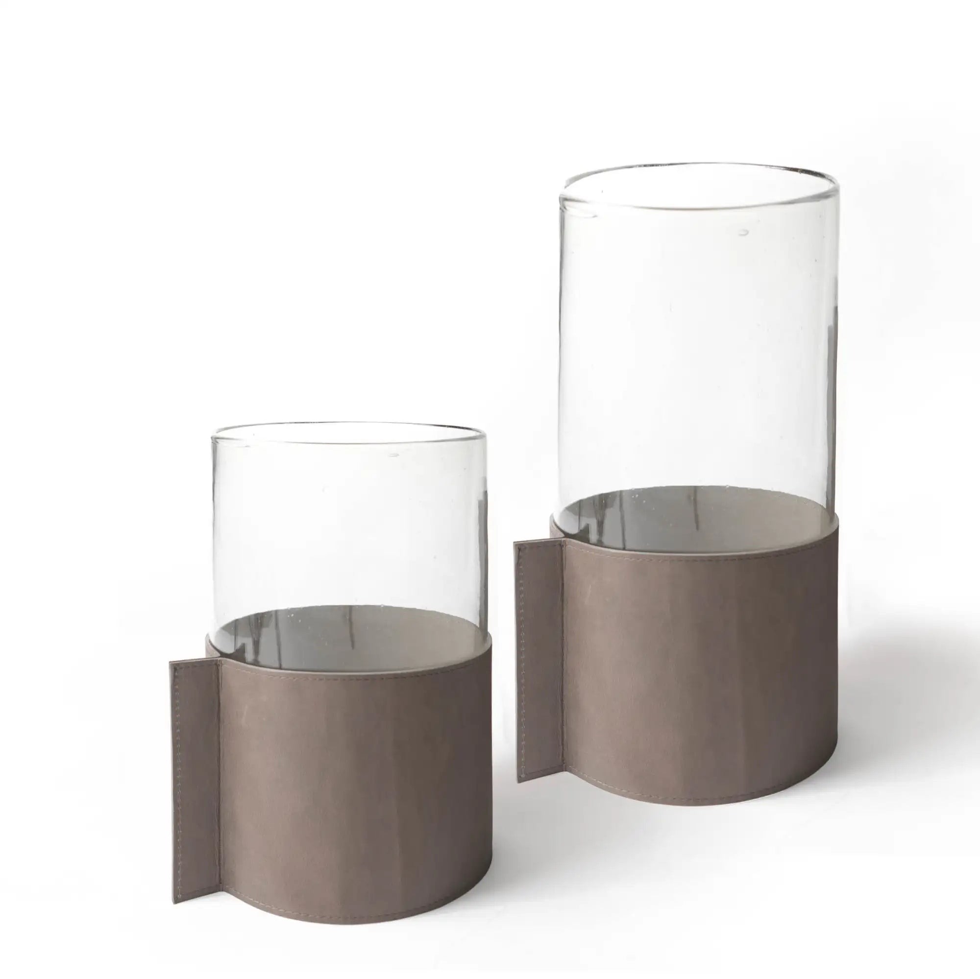 Soportes modernos para velas de vidrio con bases de metal en tono beige mate y diseño elegante y minimalista.